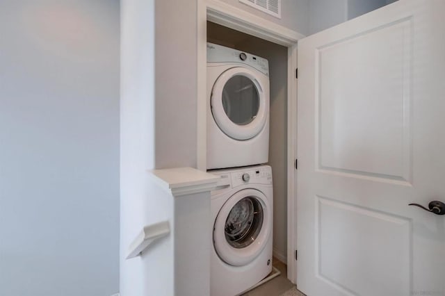 clothes washing area featuring stacked washer and dryer