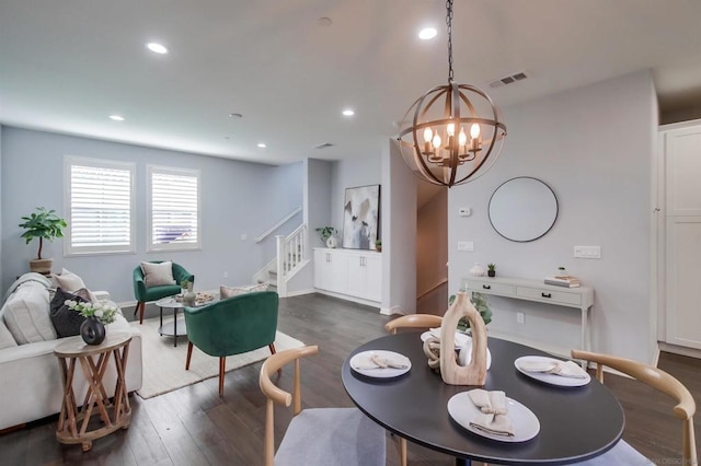 dining space with dark wood-type flooring and a chandelier