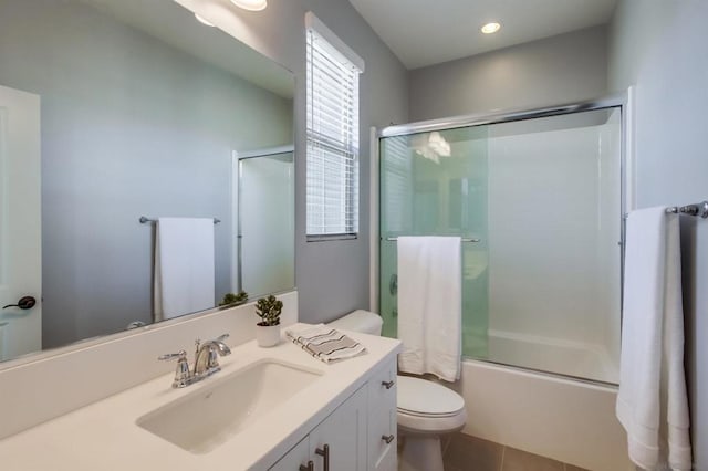 full bathroom featuring vanity, combined bath / shower with glass door, tile patterned floors, and toilet