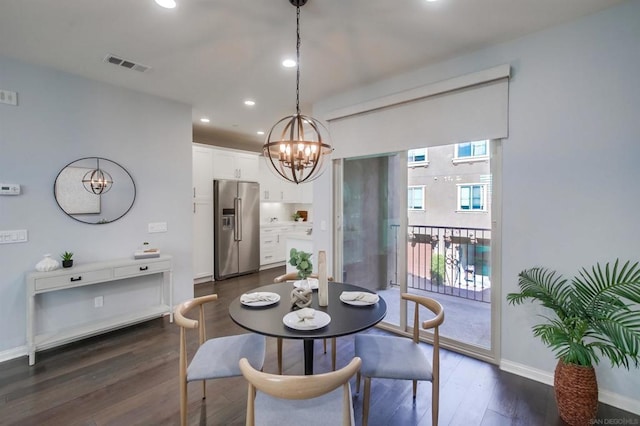 dining space with dark hardwood / wood-style floors and an inviting chandelier