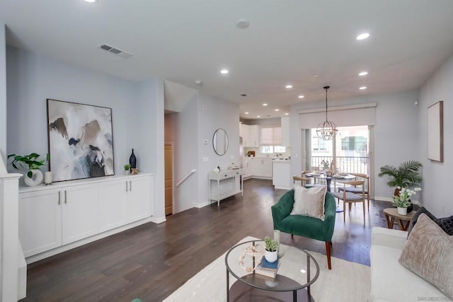 living room featuring dark hardwood / wood-style flooring and an inviting chandelier