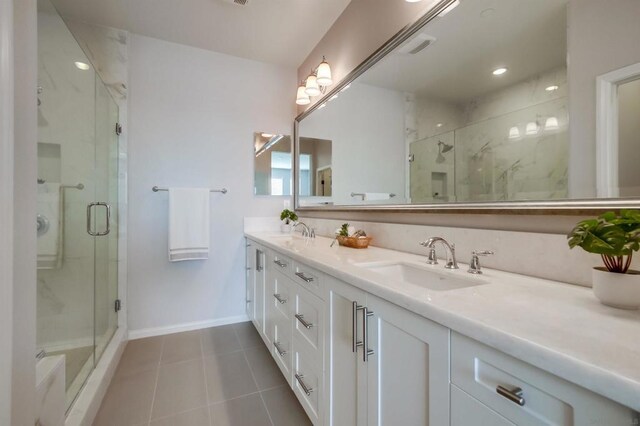 bathroom featuring vanity, a shower with shower door, and tile patterned floors