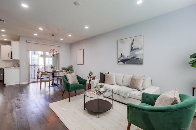 living room with dark hardwood / wood-style flooring and a notable chandelier