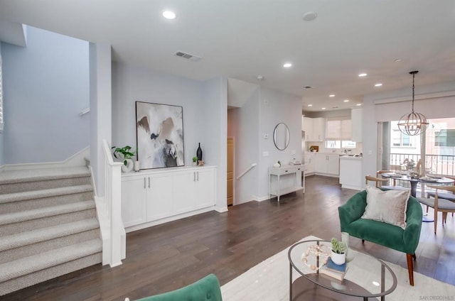 living room with dark wood-type flooring and a chandelier