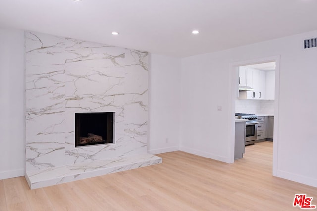 unfurnished living room featuring a fireplace and light hardwood / wood-style floors