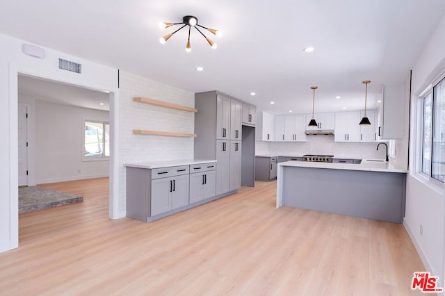 kitchen with decorative light fixtures, sink, light hardwood / wood-style flooring, and gray cabinetry