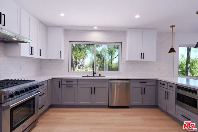 kitchen featuring white cabinets, appliances with stainless steel finishes, light hardwood / wood-style flooring, and gray cabinetry