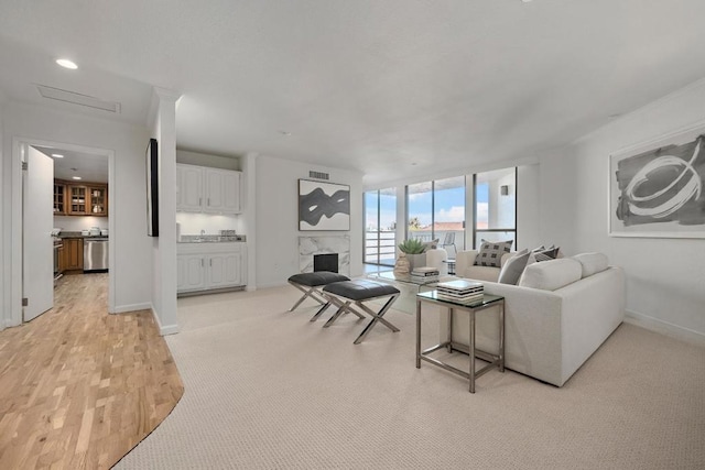 living room featuring expansive windows, a fireplace, and light hardwood / wood-style floors