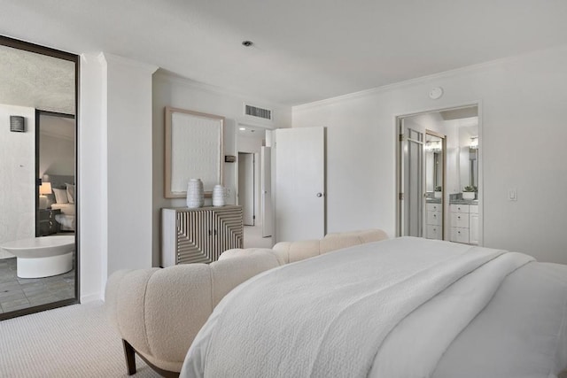 carpeted bedroom with ornamental molding and ensuite bath