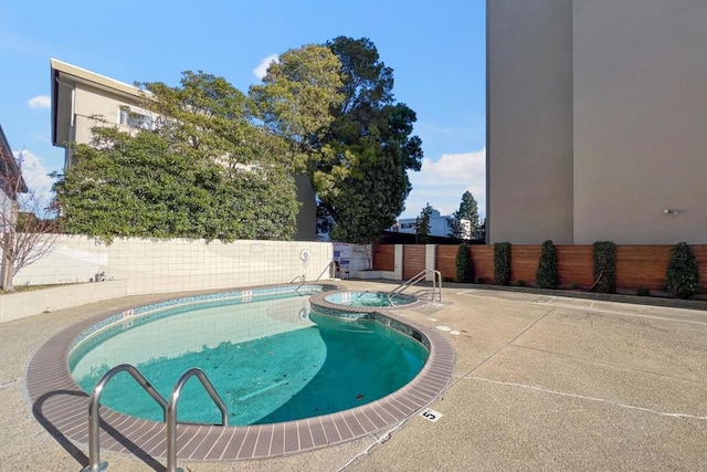 view of swimming pool with a community hot tub and a patio