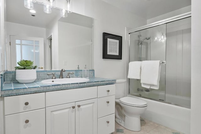 full bathroom with tile patterned flooring, vanity, shower / bath combination with glass door, and toilet