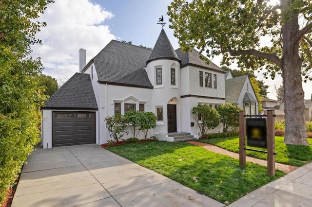 view of front of home with a garage and a front lawn