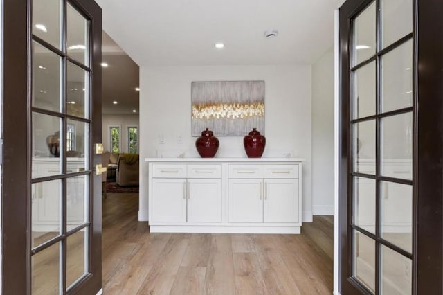 interior space with white cabinetry and light hardwood / wood-style flooring