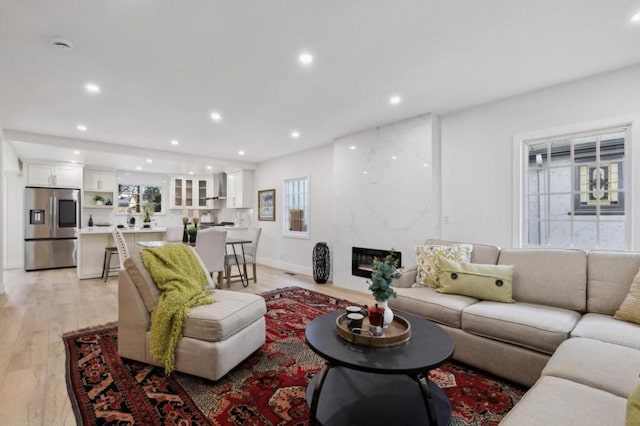 living room with light hardwood / wood-style floors and a premium fireplace