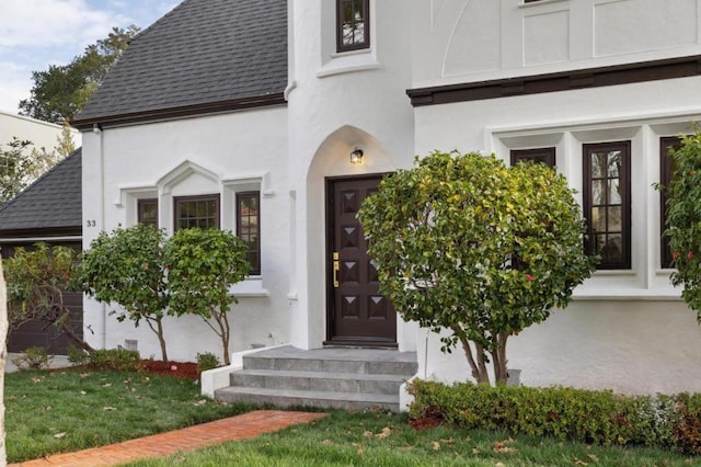 doorway to property with a lawn