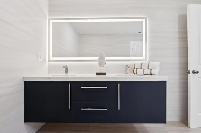 bathroom with vanity and tile walls