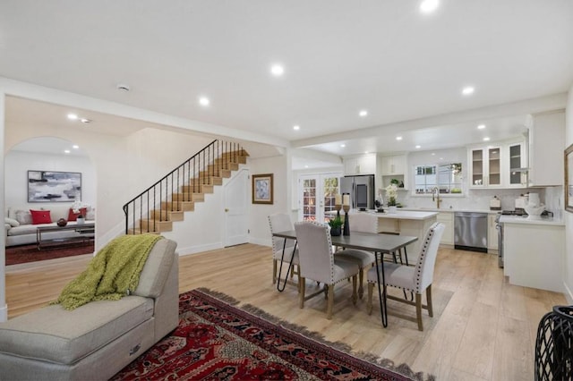 dining space featuring sink, light hardwood / wood-style floors, and french doors