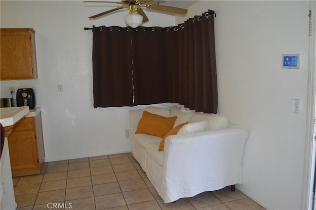 living area featuring light tile patterned flooring and ceiling fan