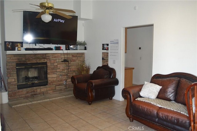 tiled living room featuring ceiling fan and a fireplace