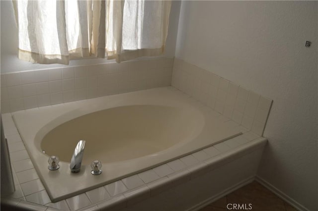 bathroom featuring tile patterned flooring and tiled tub