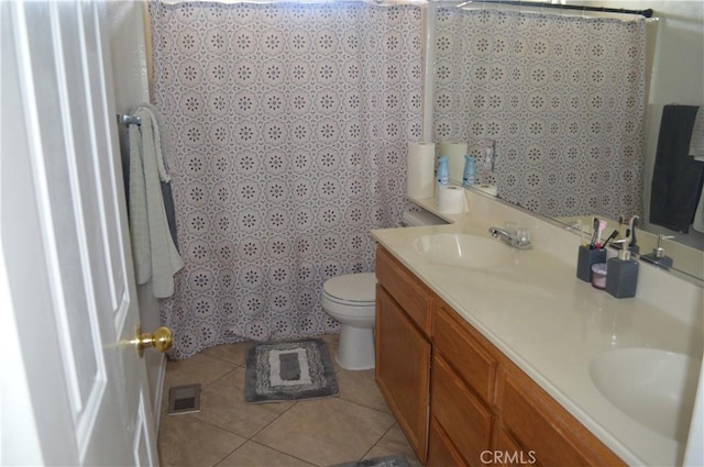 bathroom featuring vanity, toilet, and tile patterned flooring