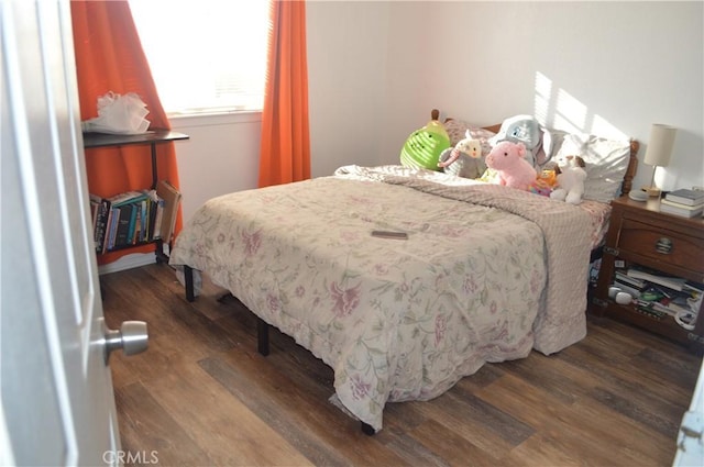 bedroom with dark wood-type flooring