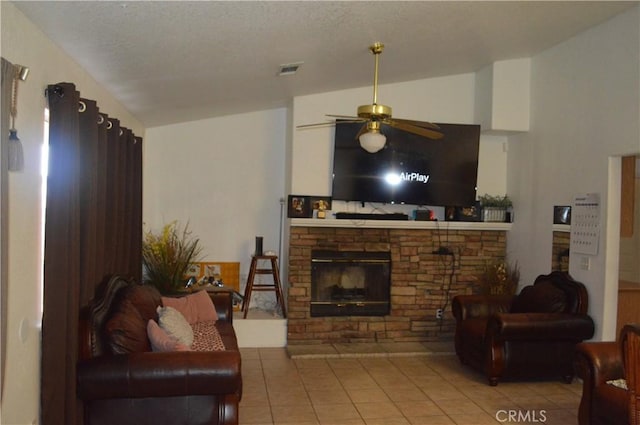 living room featuring lofted ceiling, a fireplace, tile patterned floors, and ceiling fan