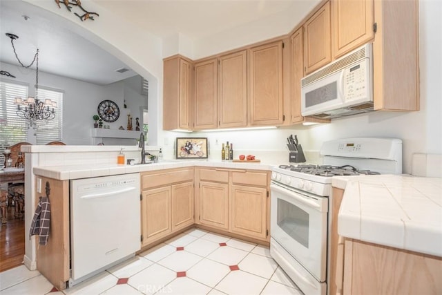 kitchen with light brown cabinetry, sink, tile counters, kitchen peninsula, and white appliances