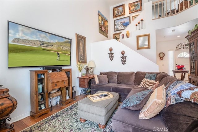 living room featuring hardwood / wood-style flooring and a towering ceiling