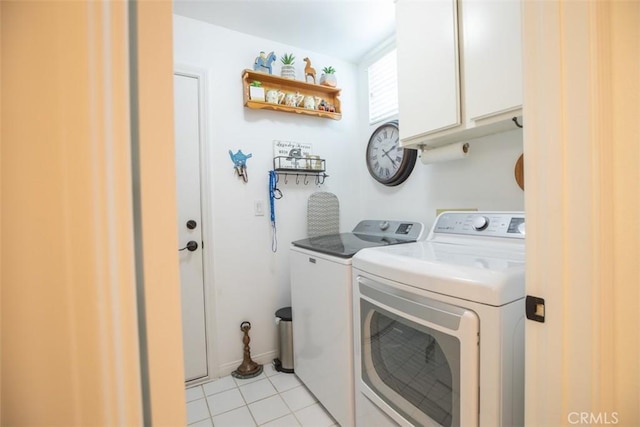 laundry area featuring cabinets, washing machine and dryer, and light tile patterned floors