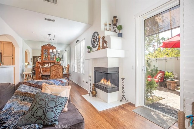 living room featuring a multi sided fireplace and hardwood / wood-style floors