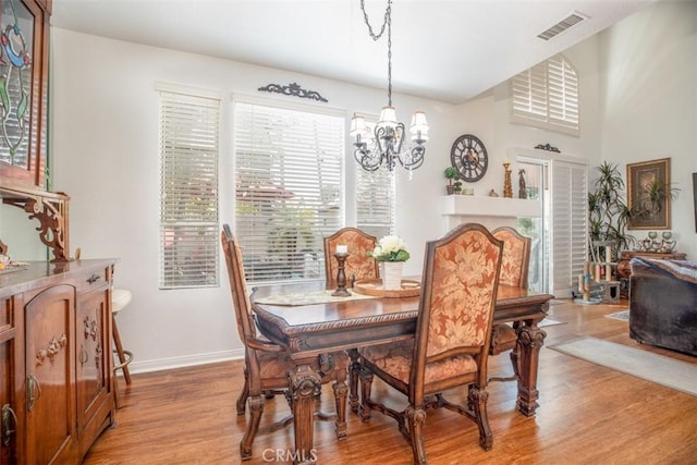 dining space featuring light hardwood / wood-style floors and an inviting chandelier