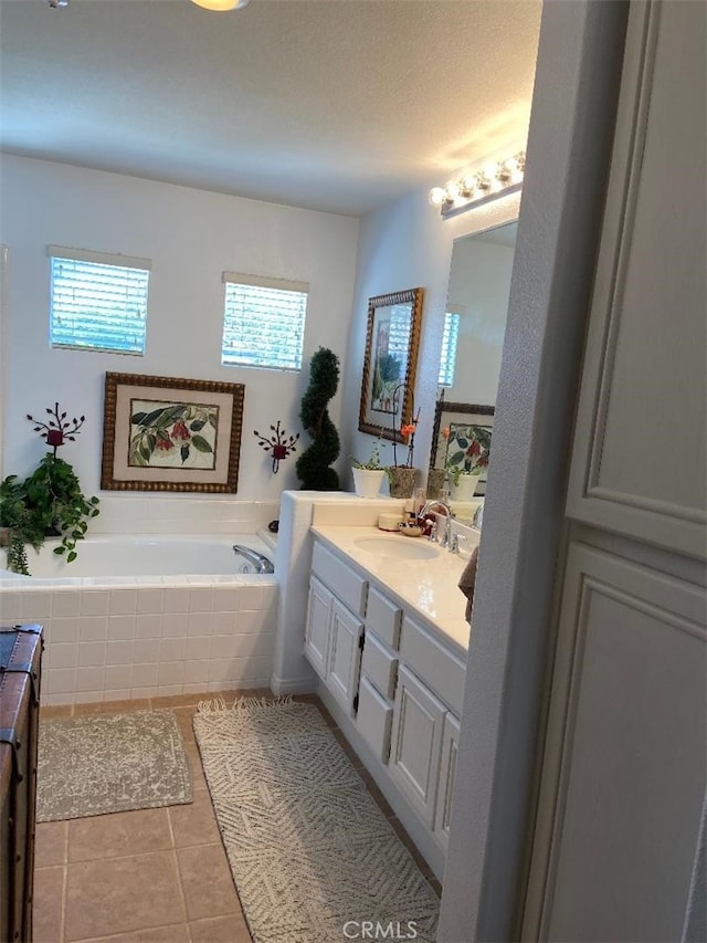 bathroom featuring vanity, tile patterned flooring, and a relaxing tiled tub