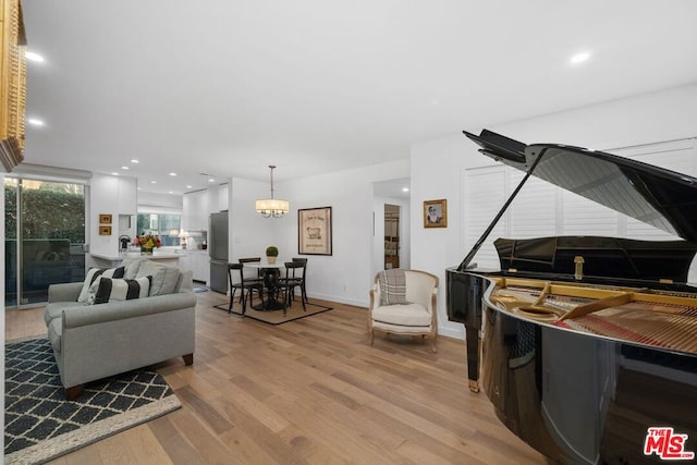 living room with a chandelier and light hardwood / wood-style floors