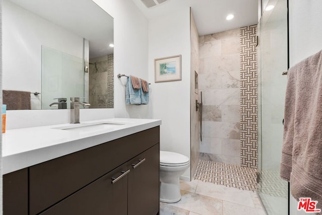 bathroom featuring vanity, toilet, and a shower with door