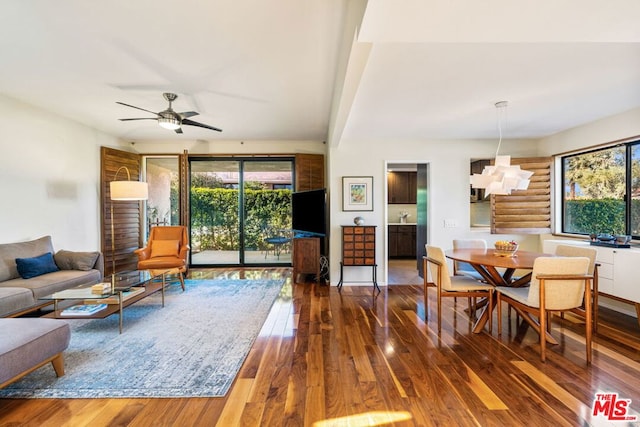 living room with hardwood / wood-style flooring, ceiling fan, and log walls