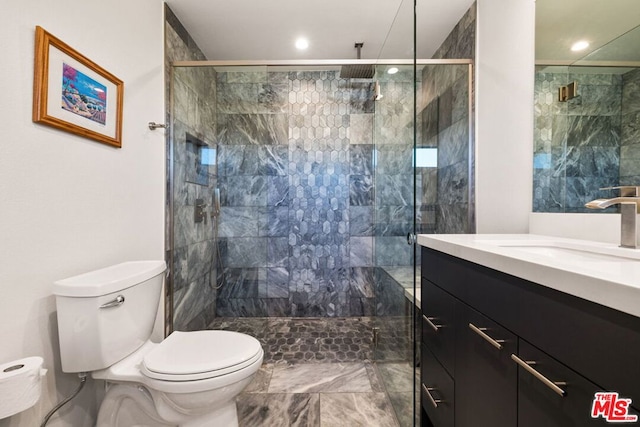 bathroom with vanity, toilet, and a tile shower