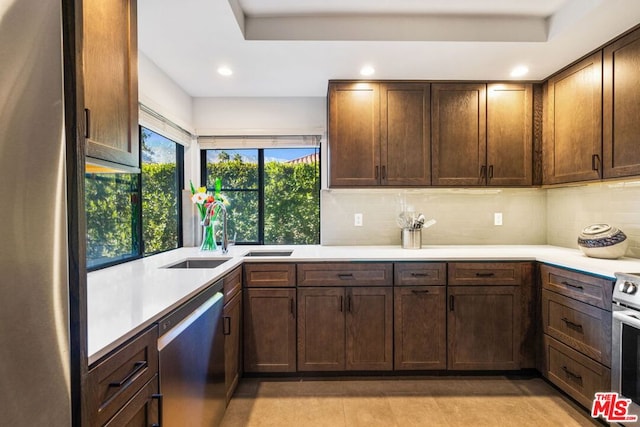 kitchen with tasteful backsplash, sink, stainless steel appliances, and light tile patterned flooring