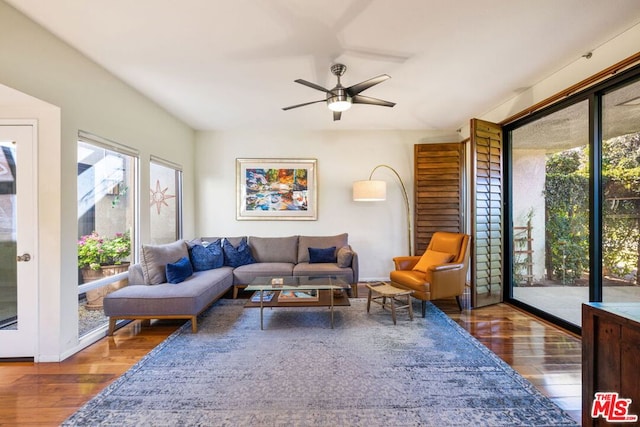 living room with dark hardwood / wood-style flooring and ceiling fan