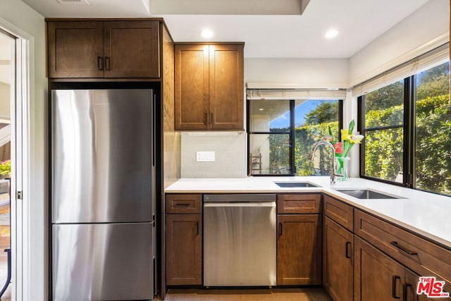 kitchen featuring stainless steel appliances, tasteful backsplash, and sink