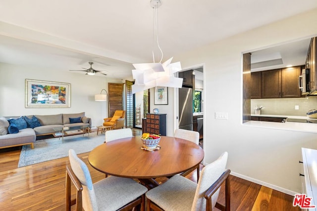 dining area with ceiling fan and dark hardwood / wood-style floors