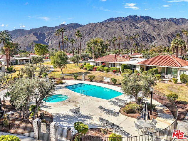 view of pool with a mountain view, a community hot tub, and a patio