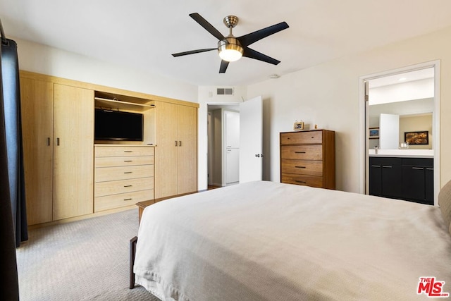 carpeted bedroom featuring ensuite bathroom, ceiling fan, and a closet