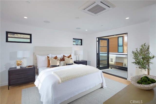 bedroom with light wood-type flooring and access to outside