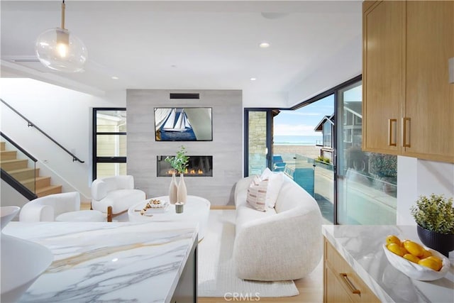 living room featuring a large fireplace and a water view