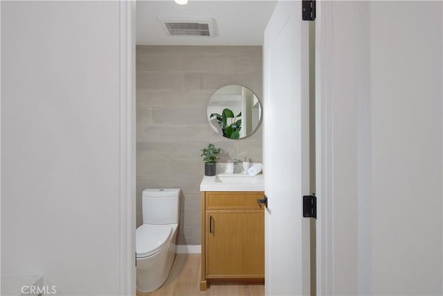 bathroom featuring toilet, vanity, and wood-type flooring