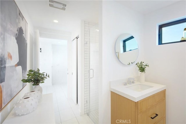 bathroom featuring tile patterned flooring, an enclosed shower, and vanity