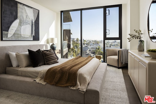 bedroom with hardwood / wood-style flooring, floor to ceiling windows, and multiple windows