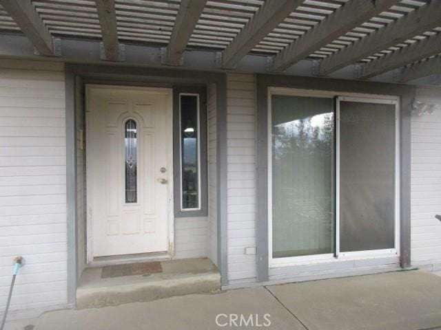 doorway to property with a pergola