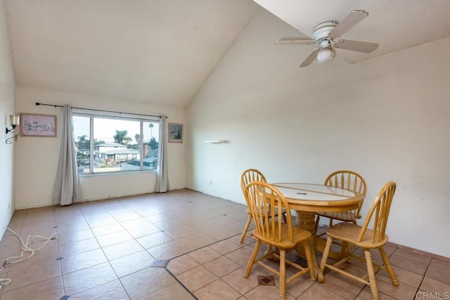 tiled dining room with lofted ceiling and ceiling fan